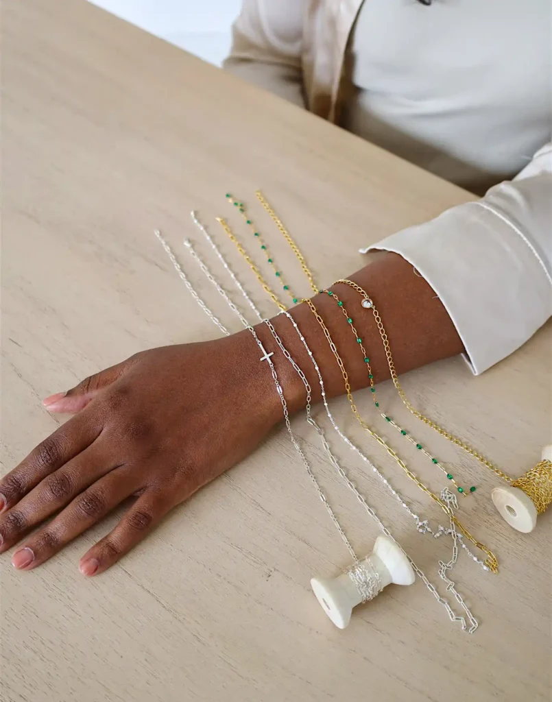 Arm displaying various gold and silver chain bracelets.