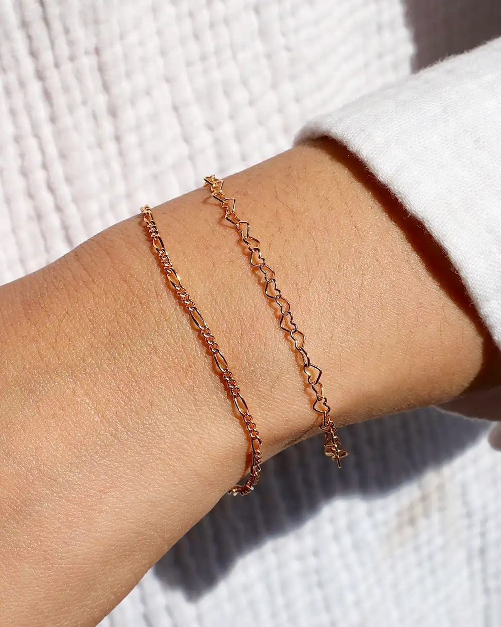 Two gold bracelets on wrist
