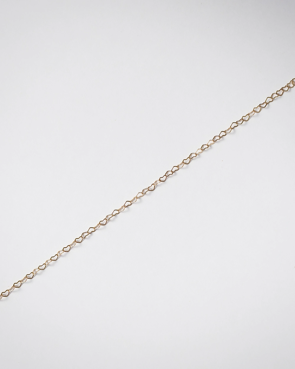 Delicate gold chain on white background.