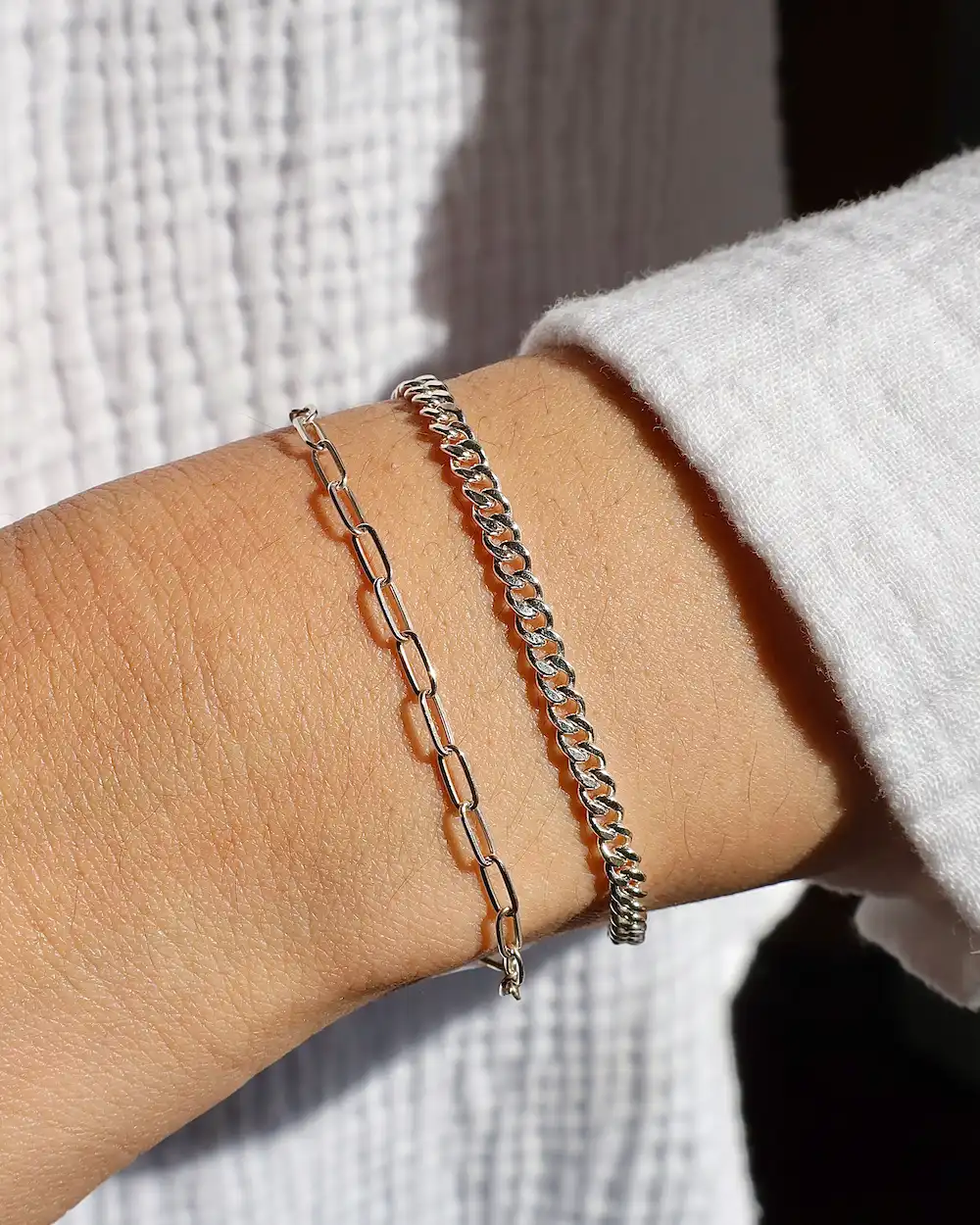 Silver chain bracelets on wrist close-up