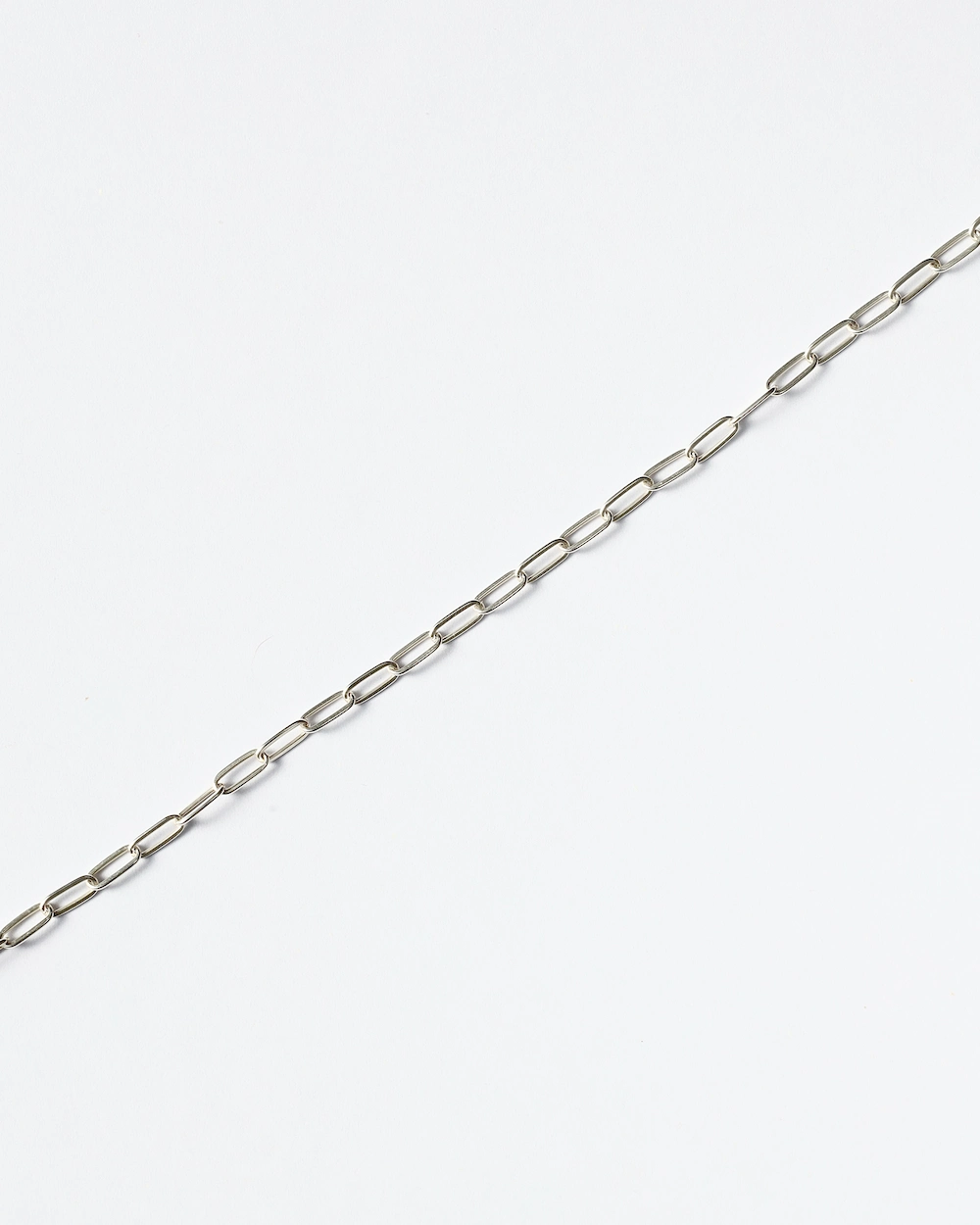 Silver chain necklace on white background.