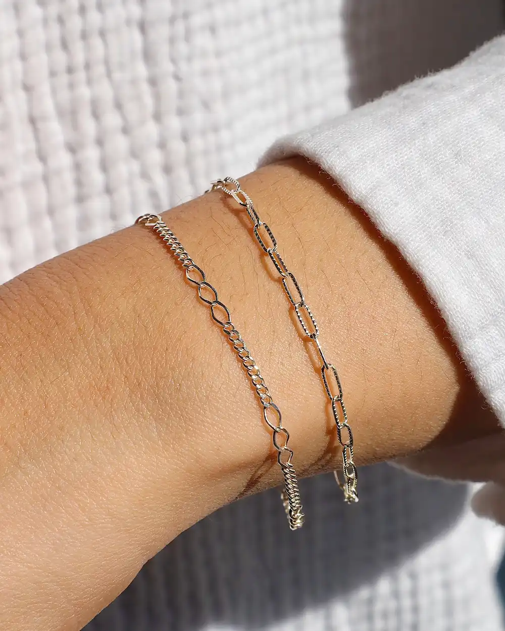 Silver chain bracelets on wrist close-up