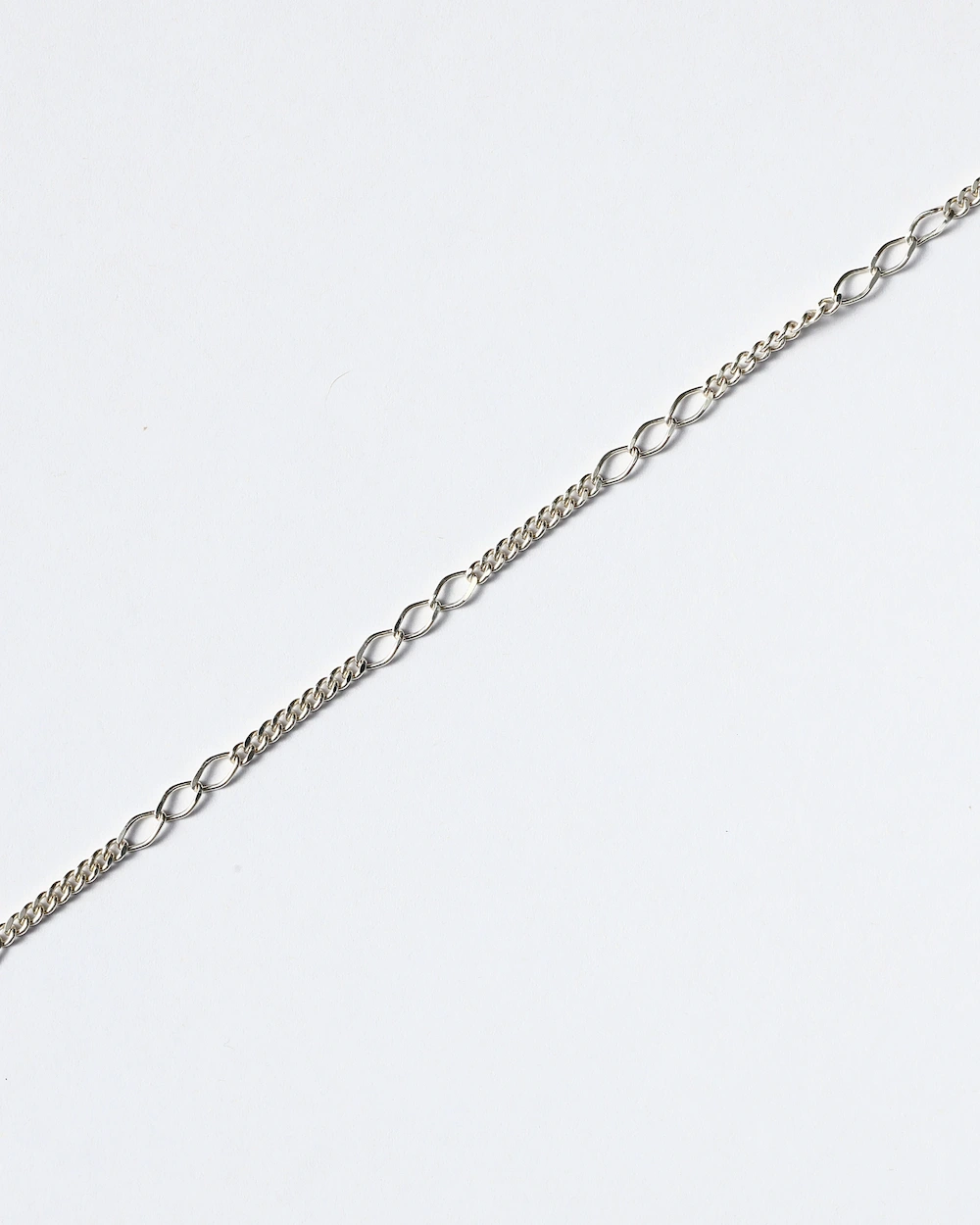 Delicate silver chain on white background.
