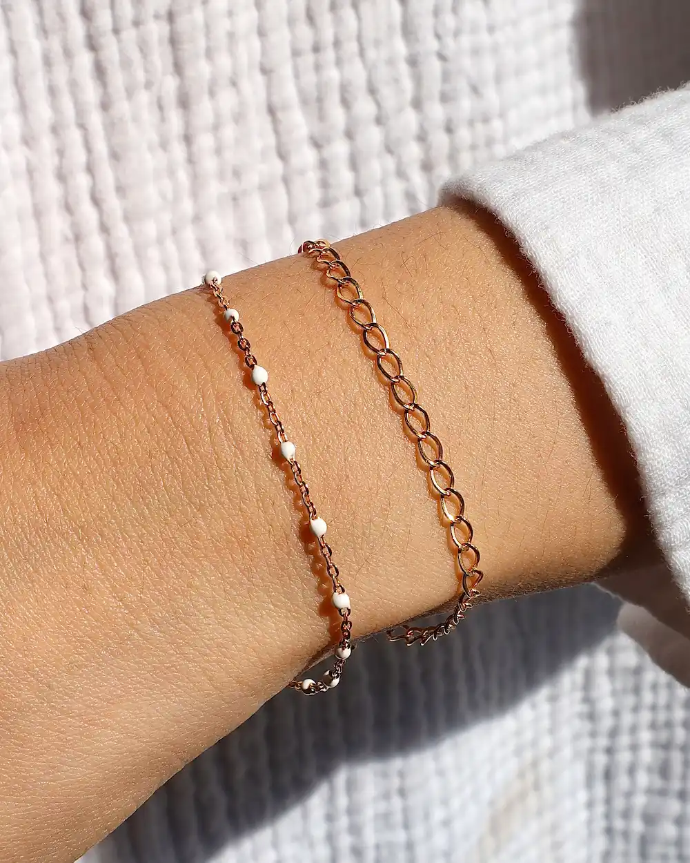 Rose gold bracelets on a wrist.