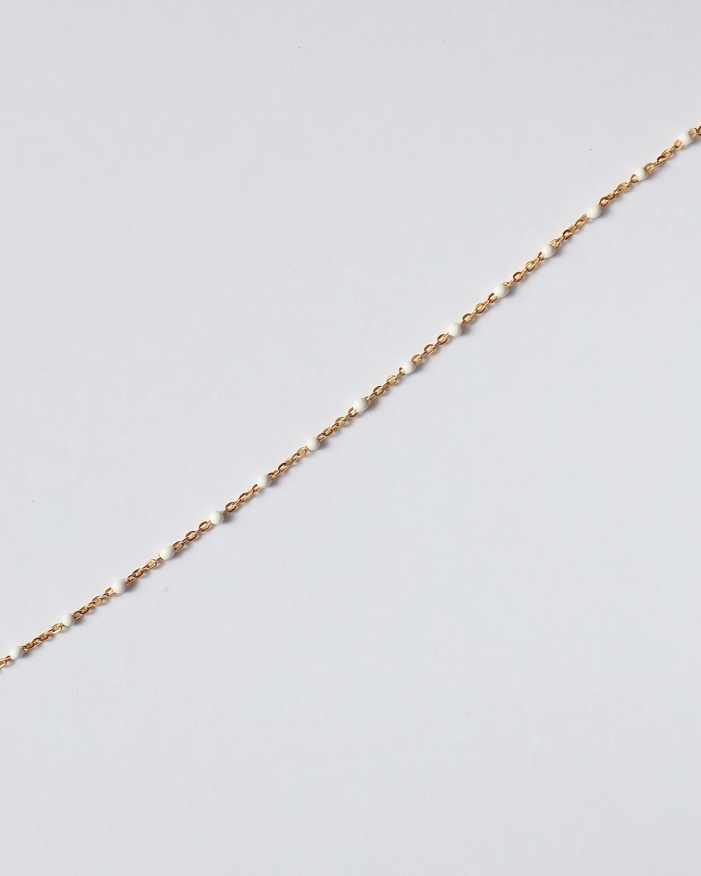 Delicate gold chain with small white beads
